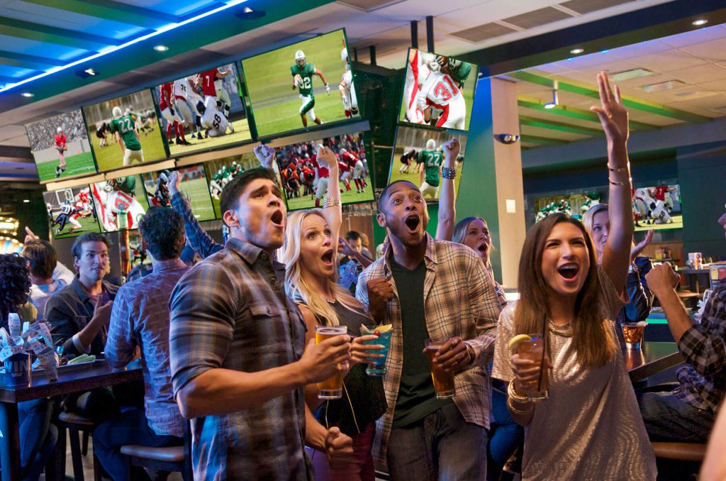 Crowd cheering in a bar watching sports