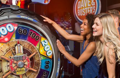 Friends spinning a large game wheel for prizes