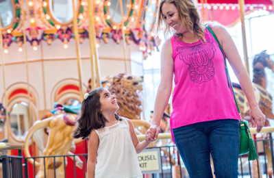 Mom and daughter next to a carousel