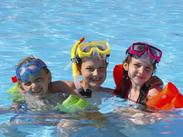 kids in the pool with floaties and goggles