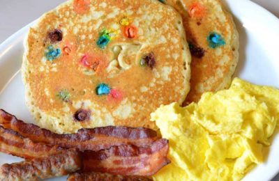 Pancakes with candy and bacon and scrambled eggs