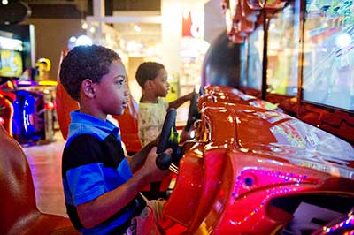 kids playing a racing arcade game