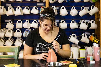 Girl painting pottery