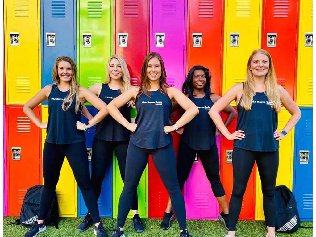 group of girls standing in front of colored lockers