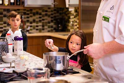 girl cooking over stove