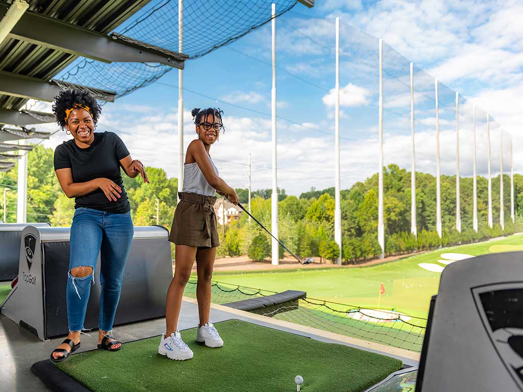 mom and daughter playing at topgolf