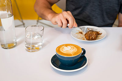 guy eating with coffee in front of him