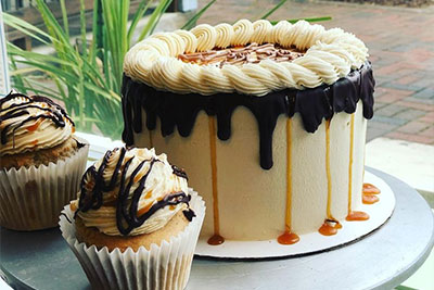 vanilla cakes with chocolate drizzle next to cupcakes