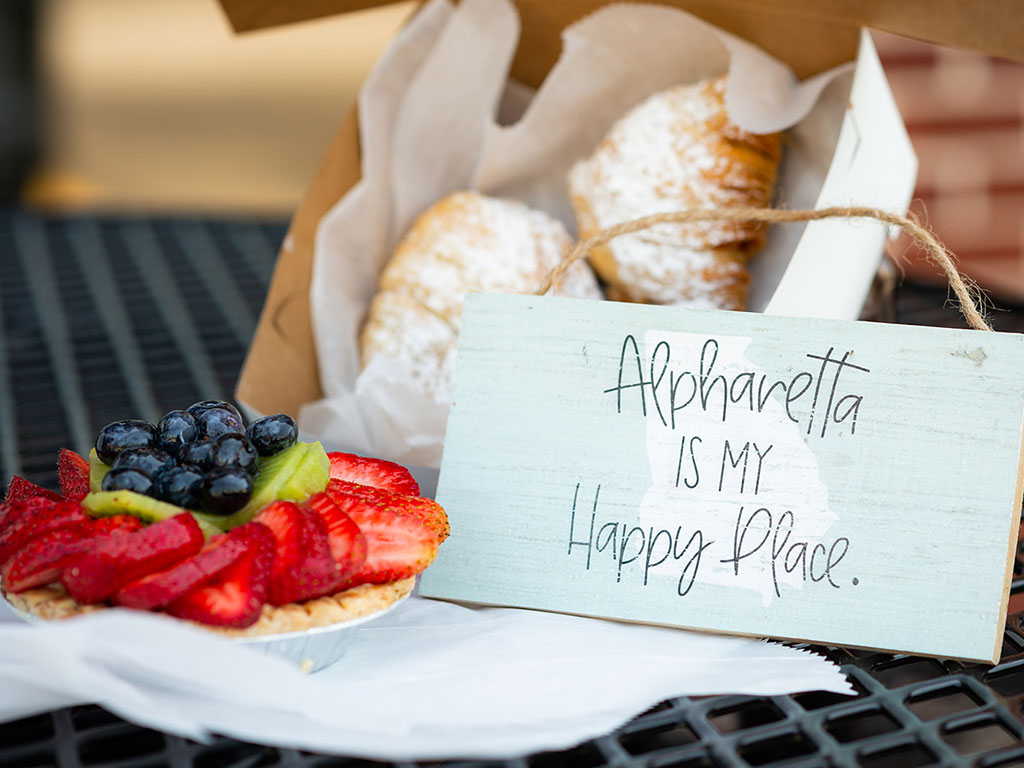 fruit tart and baked good next to sign