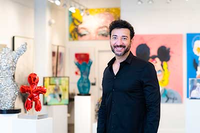 guy in black shirt standing in front of artwork
