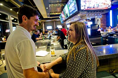 couple at bar holding hands