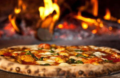 pizza in front of wood fire oven