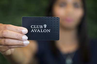 woman holding club avalon card