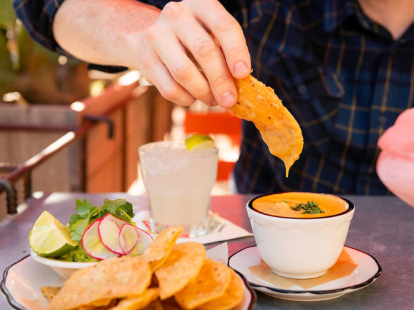 guy dipping chip into queso