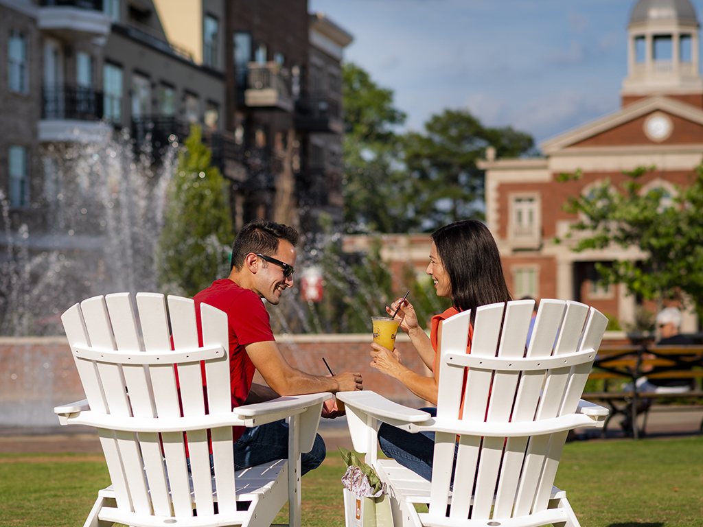 couple sitting outside in chairs with drinks