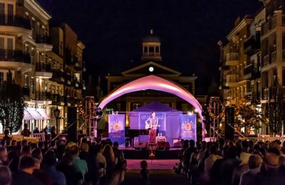 guy playing guitar on stage at night