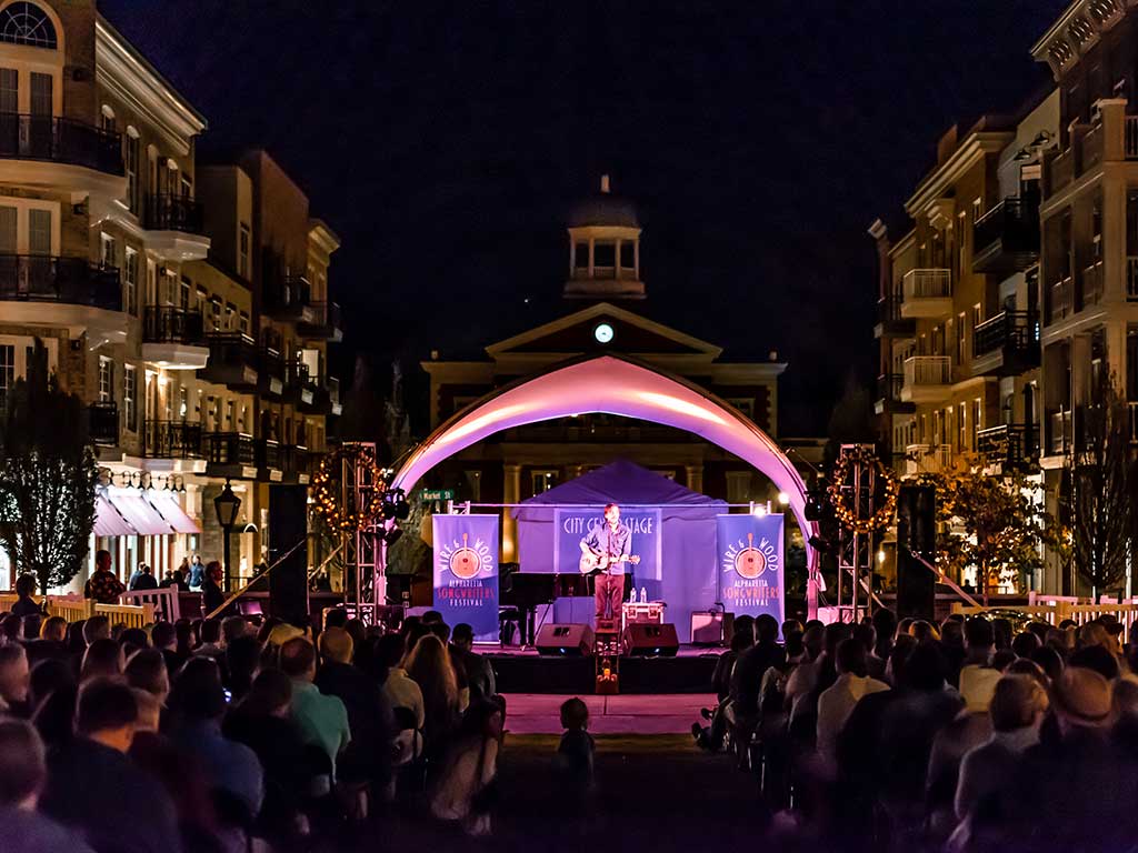 guy playing guitar on stage at night