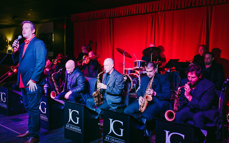 man singing on stage with band