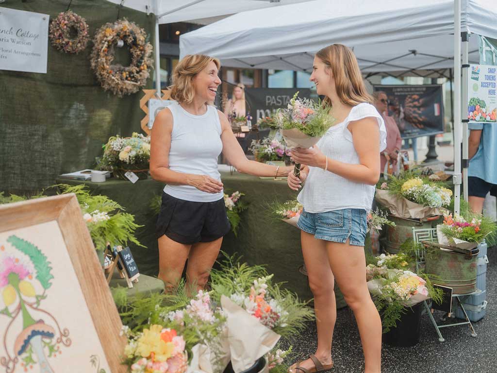 downtown-farmers market-woman-vendor-customer-flowers