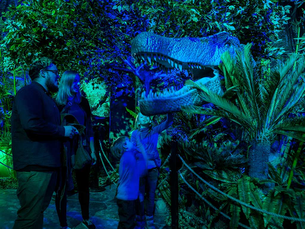 family looking at dinosaur exhibit