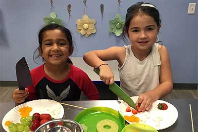 girls chopping fruit