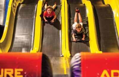 Kids sliding down slides on their stomach