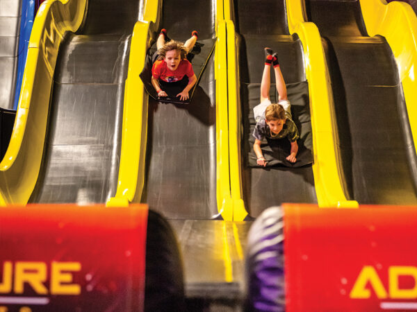 Kids sliding down slides on their stomach
