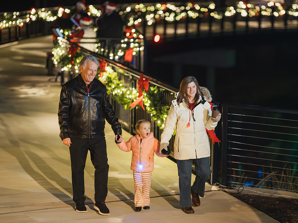 Grandparents and granddaughter taking a stroll on the Lights on the Loop event on the Alpha Loop.